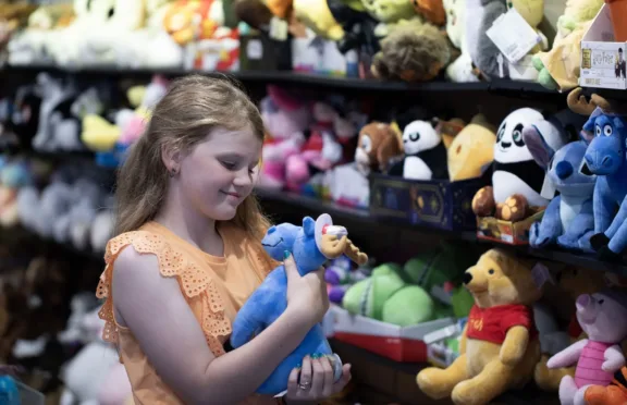 Child holding a blue moose stuffed animal at Blue Moose Toys on Clifton Hill.
