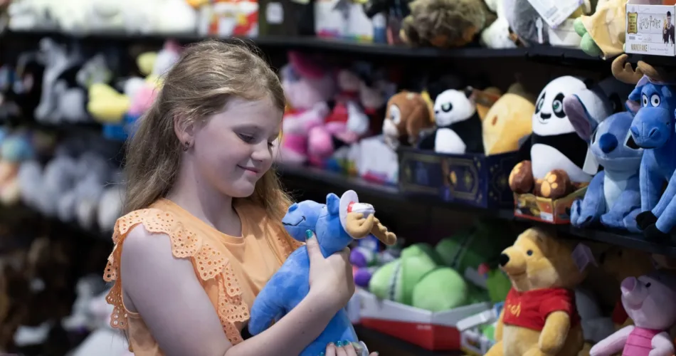 Child holding a blue moose stuffed animal at Blue Moose Toys on Clifton Hill.